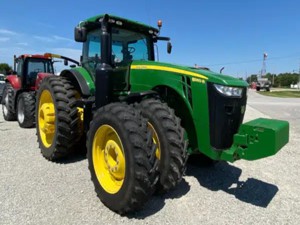 Used tractor John Deere 8360R for sale in equipment lot. Next to other farm machinery for sale