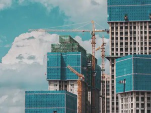 Many construction cranes building skyscrapers